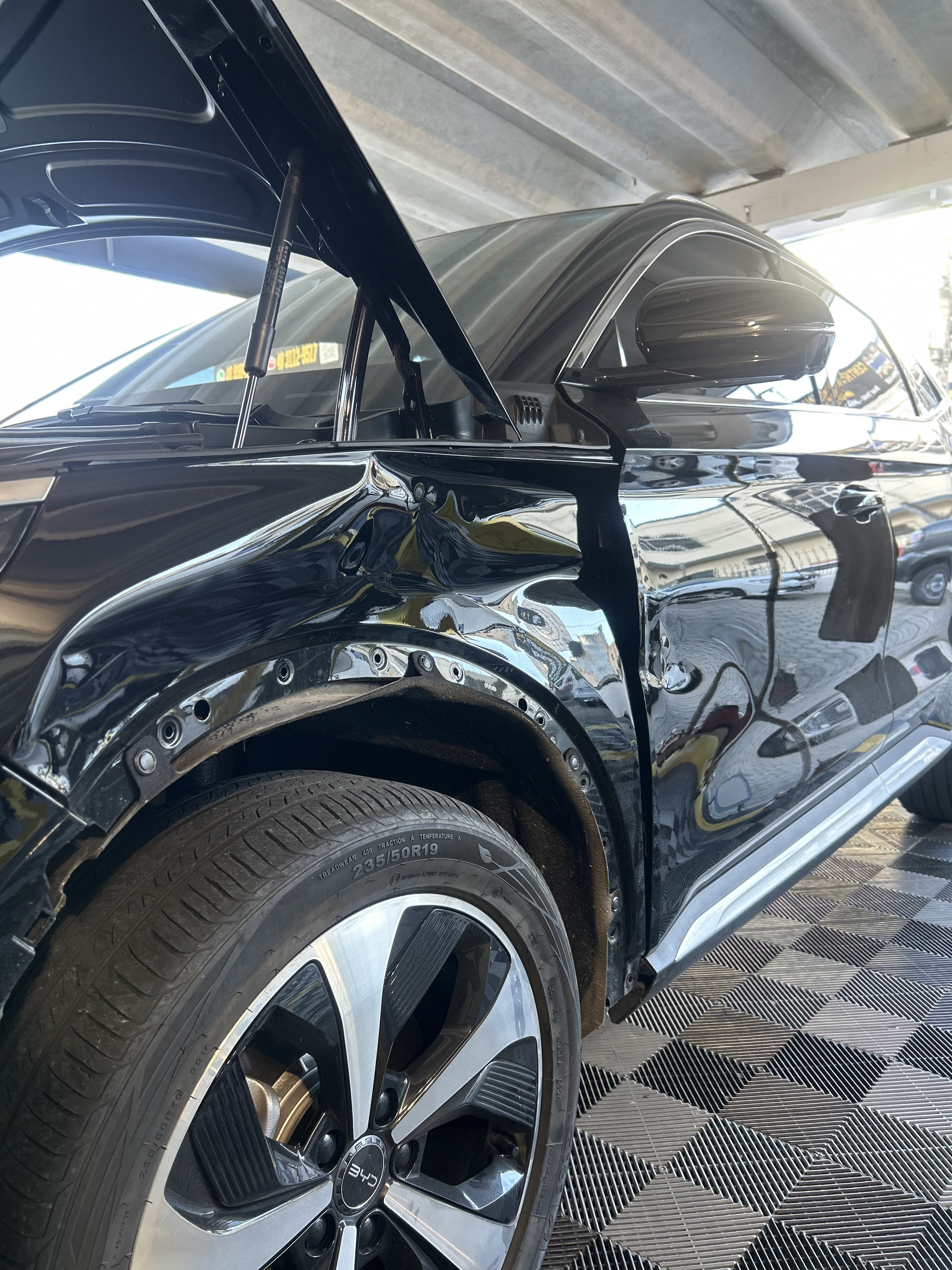 Lateral dianteira de carro branco com amassado na porta