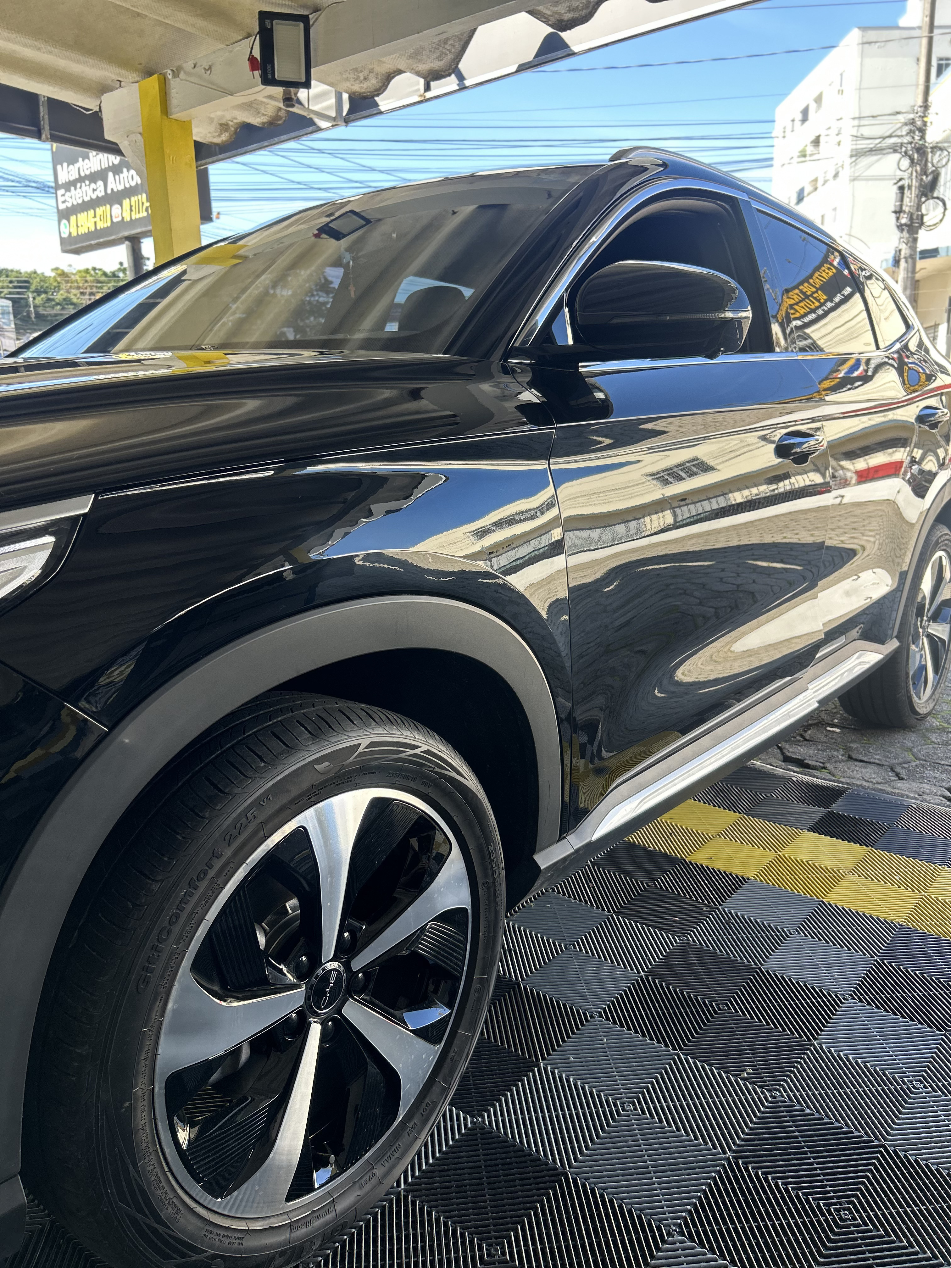 Lateral dianteira do mesmo carro branco com a lataria lisa