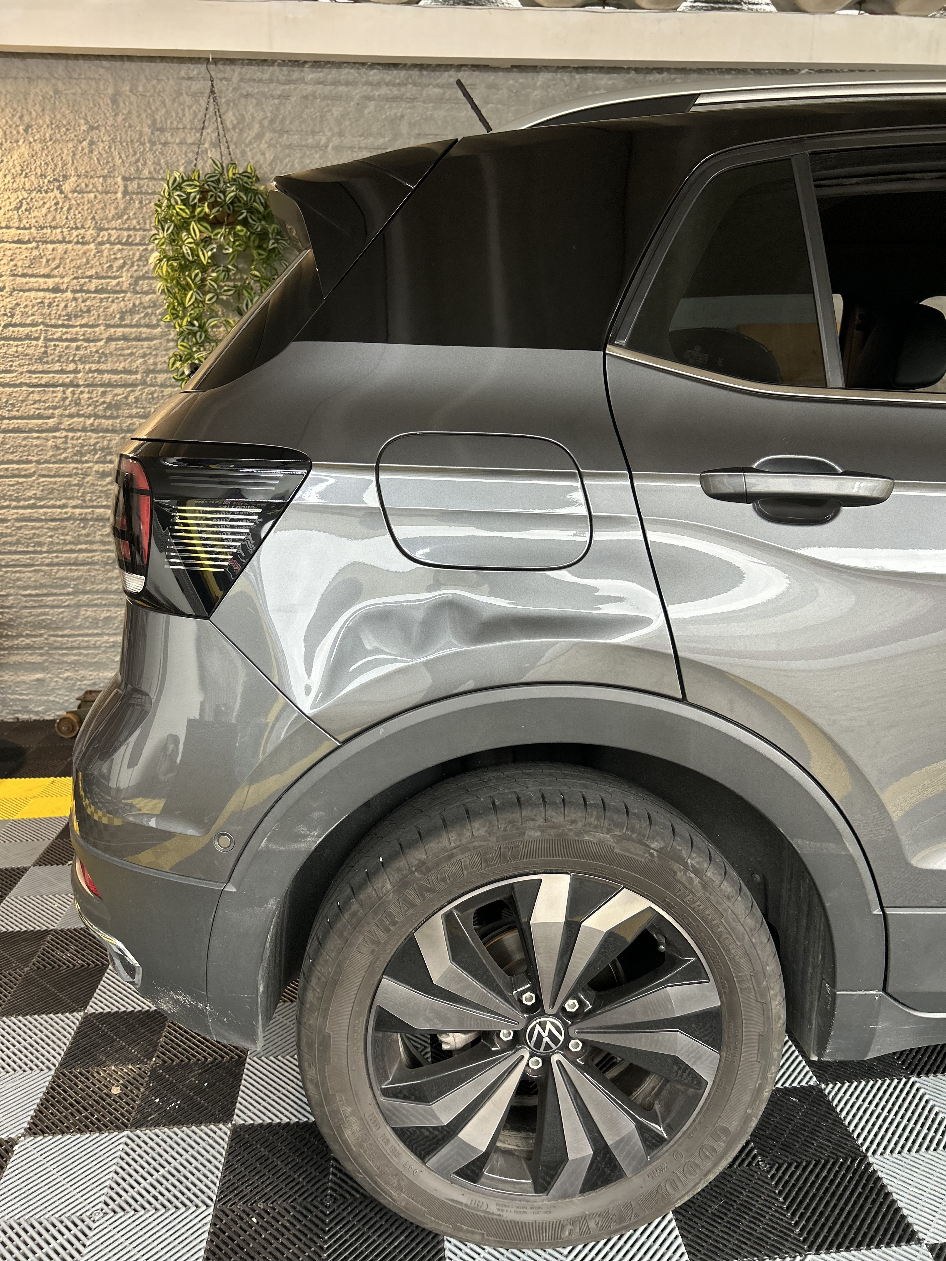 Traseira de SUV cinza com amassado no para-choque e lateral